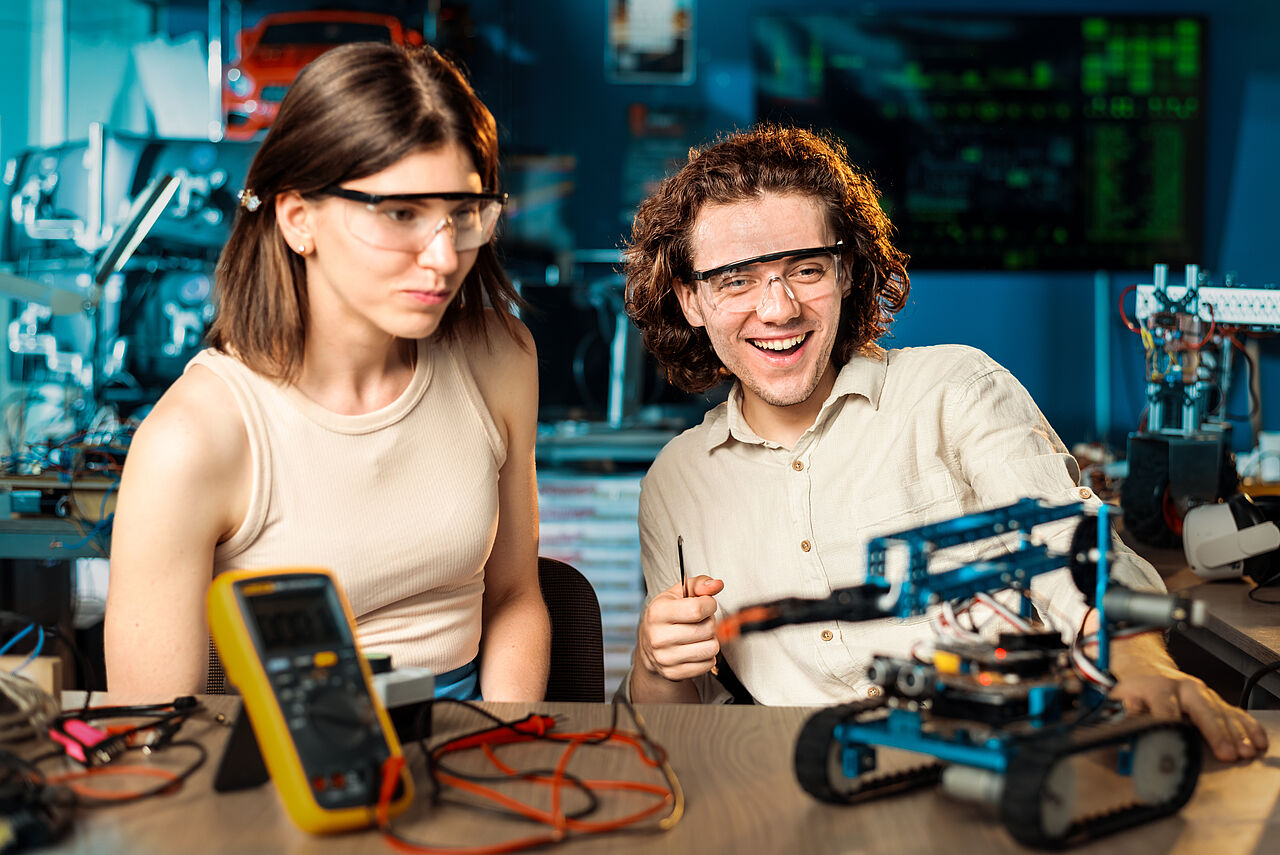 Young man and woman doing experiments in robotics in a laboratory