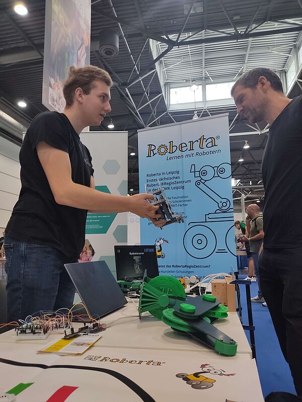 Zwei Männer diskutieren Robotik-Teile